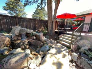 einen Hinterhof mit einem Steingarten mit einer Treppe und einem Sonnenschirm in der Unterkunft Estes Mountain Inn in Estes Park