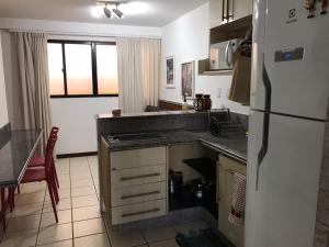 a kitchen with a refrigerator and a counter top at Atlântico Flat 209 in Natal