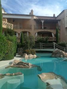 a swimming pool in front of a house at APPARTAMENTO VILLAGGIO CASCINA - JESOLO in Lido di Jesolo