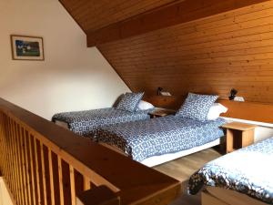 a attic room with two beds and a staircase at Cottage Anadwen au pied du lac au duc et son golf in Ploërmel
