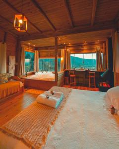 a large bedroom with a large bed and a desk at Pousada Flor de Lótus dos Canyons in Praia Grande