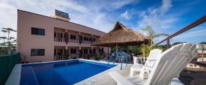 a resort with a swimming pool with chairs and an umbrella at Quinta Suites in Cozumel