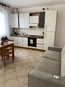 a kitchen with a couch and a table and a refrigerator at OTB Italia 2 - Alloggio accogliente tra Venezia e Treviso con 2 Terrazze e Posto auto Coperto in Preganziol