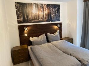 een slaapkamer met een bed met een houten hoofdeinde bij Ferienwohnung ViOs im Haus Castello in Grächen