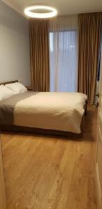 1 dormitorio con cama y ventana grande en Apartment - 200 m Near Central Park, en Tiflis