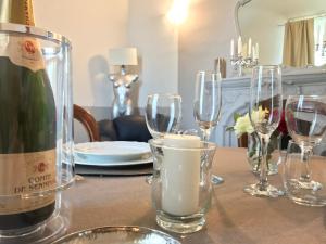 a table with wine glasses and a bottle of wine at B&B Villa Prestigio in Novi Ligure