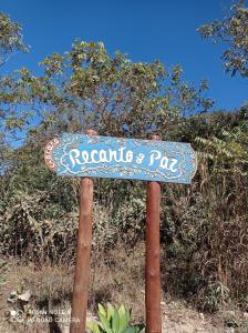 a sign for a rousdsipsips pad in front of trees at Chácara Recanto da Paz in Cavalcante