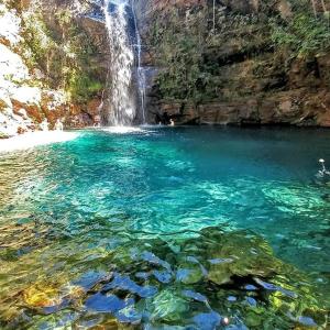 einen Pool mit blauem Wasser und Wasserfall in der Unterkunft Chácara Recanto da Paz in Cavalcante