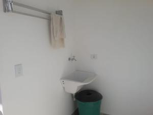 uma casa de banho com um lavatório e uma lata de lixo em Chalé Isabela em Ubatuba
