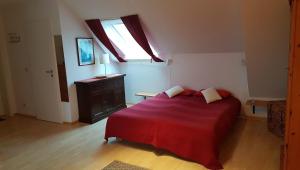 a bedroom with a red bed and a window at Birkenstraße 15b App 14 in Zingst