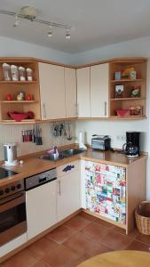 a kitchen with white cabinets and a sink at Birkenstraße 15b App 14 in Zingst