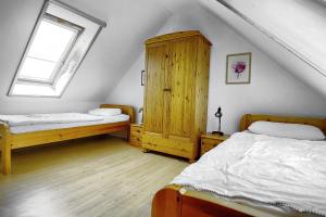 a bedroom with two beds and a wooden cabinet at Am Strand 4,PP innen in Zingst