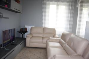 a living room with two white couches and a tv at My Home Milano ! in Milan