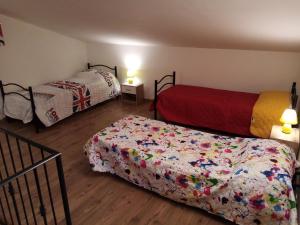 1 dormitorio con 2 camas y colcha con flores en La Casa di nonna Adri - Casa vacanze in Casentino en Stia