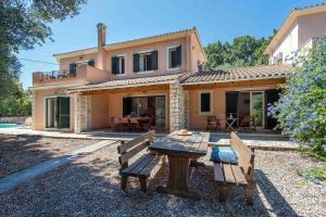 a house with a picnic table in front of it at Villa Dimitris Beach in Kassiopi