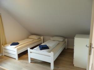 two beds in a attic with blue towels on them at Ferienhaus Sonnenblick - a59190 in Walsrode