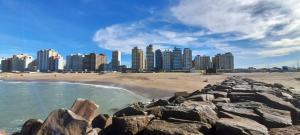 a view of a beach with buildings in the background at Hotel Rincón de Playa in Miramar