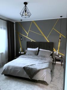 a bedroom with a large bed with yellow triangles on the wall at Apartament Royal in Dej