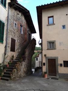 um beco num antigo edifício de pedra com escadas em La Casa di nonna Adri - Casa vacanze in Casentino em Stia