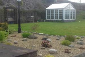 a garden with a greenhouse in the back yard at Drumgowan House in Donegal