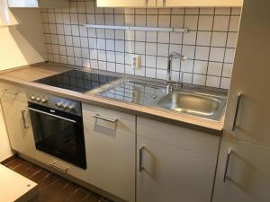 a kitchen with a sink and a stove at Ferienhaus Stausee Bitburg in Biersdorf