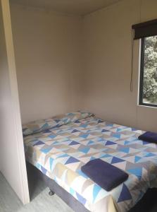 ein Schlafzimmer mit einem Bett in einem Zimmer mit einem Fenster in der Unterkunft Whatuwhiwhi TOP 10 Holiday Park in Tokerau Beach