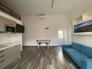 - un salon avec un canapé bleu et une table dans l'établissement Monolocale Agata, à Sestri Levante