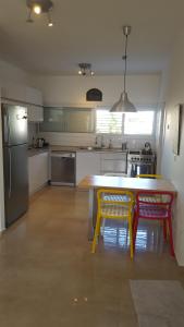 uma cozinha com uma mesa de madeira e 2 cadeiras em Room near Sheba Medical Center, and Bar Ilan, and TLV Airport em Qiryat Ono