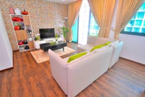a living room with a white couch and a tv at Vivacity Jazz Suite New Luxury Vivacity Cozy Home LV8 in Kuching