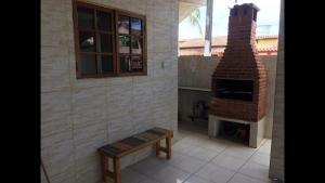 a patio with a brick fireplace and a bench at Casa Temporada Frente à Praia Piscina Ar cond Nova Viçosa VA in Nova Viçosa