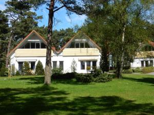 una casa blanca con árboles delante de ella en Hinter den Dünen D60, en Prerow