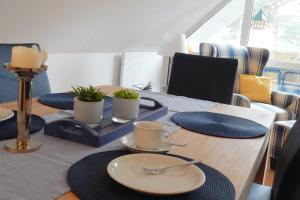 einen Esstisch mit Tellern und Küchenutensilien in der Unterkunft Hinter den Dünen D60 in Prerow