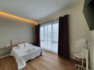 1 dormitorio con cama y ventana grande en REDONDELA APARTMENTS - Bedroom, Bathroom & Kitchen en Redondela