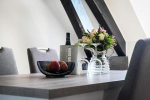 einen Tisch mit einer Flasche Wein und Erdbeeren darauf in der Unterkunft Tor-Apartment im Herrenhaus Rheinblick in Xanten
