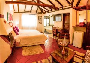 una camera da letto con un letto grande e un bagno di Hotel Bahía Olivo Boutique & Spa a Villa de Leyva