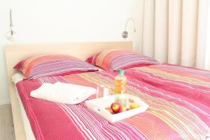 a tray of fruit and a bottle on a bed at L5 - Ferienanlage Lindenstraße 1 - FERIENDOMIZIL HOLLICH in Grömitz