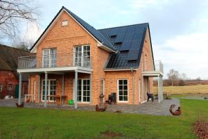 een groot bakstenen huis met zonnepanelen erop bij Herrmannshof Haby App 2 Borby in Haby