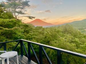 einen Balkon mit Blick auf einen roten Berg in der Unterkunft Mount Fuji Castle 2 in Yamanakako