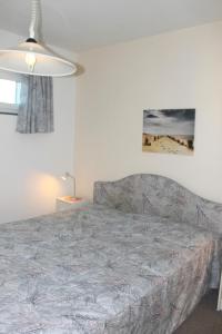 een slaapkamer met een bed en een lamp bij Haus Baltic App 132 - gleich hinter dem Deich, sonnige Balkonwohnung in Südwestlage in Grömitz
