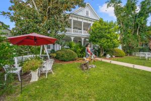 a woman standing in the yard of a house with an umbrella at Goodbread House Bed and Breakfast in Saint Marys
