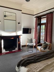 a bedroom with a bed and a fireplace and a tv at Ballina Manor Boutique Hotel in Ballina