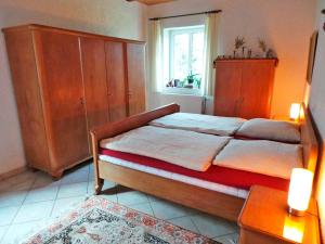 ein Schlafzimmer mit einem Bett, einer Kommode und einem Fenster in der Unterkunft Drengenberg in Hanerau-Hademarschen
