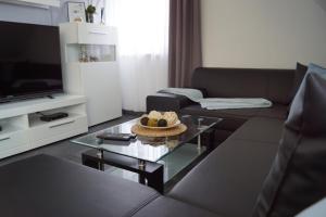 ein Wohnzimmer mit einem Sofa und einem Couchtisch aus Glas in der Unterkunft La Domus Premium Osnabrück Lotte in Gohfeld