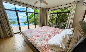 a bedroom with a bed with a view of the ocean at Villas by Tekoa in Uvita
