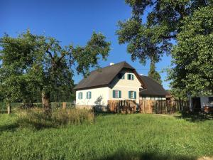 een wit huis met een zwart dak in een veld bij Kellerstöckl am veganen Bio-Lebenshof "Varm - die vegane Farm" in Sulb