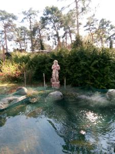 posąg chłopca stojącego w basenie z wodą w obiekcie Mediterran Suite w mieście Hoppegarten