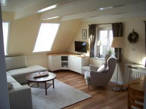 ein Wohnzimmer mit einem Sofa und einem Tisch in der Unterkunft Deichhof Whg 26 in Dunsum