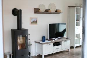 a living room with a television and a fireplace at Ostsee - Appartement Nr 95 "Möwe" im Strand Resort in Heiligenhafen