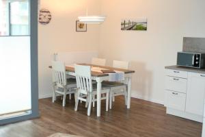 a kitchen with a dining room table and chairs at Ostsee - Appartement Nr 95 "Möwe" im Strand Resort in Heiligenhafen