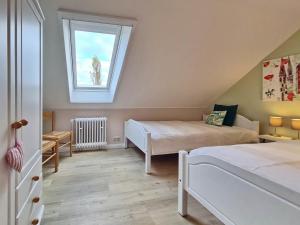1 dormitorio en el ático con 2 camas y ventana en TausendSchön, en Vadersdorf